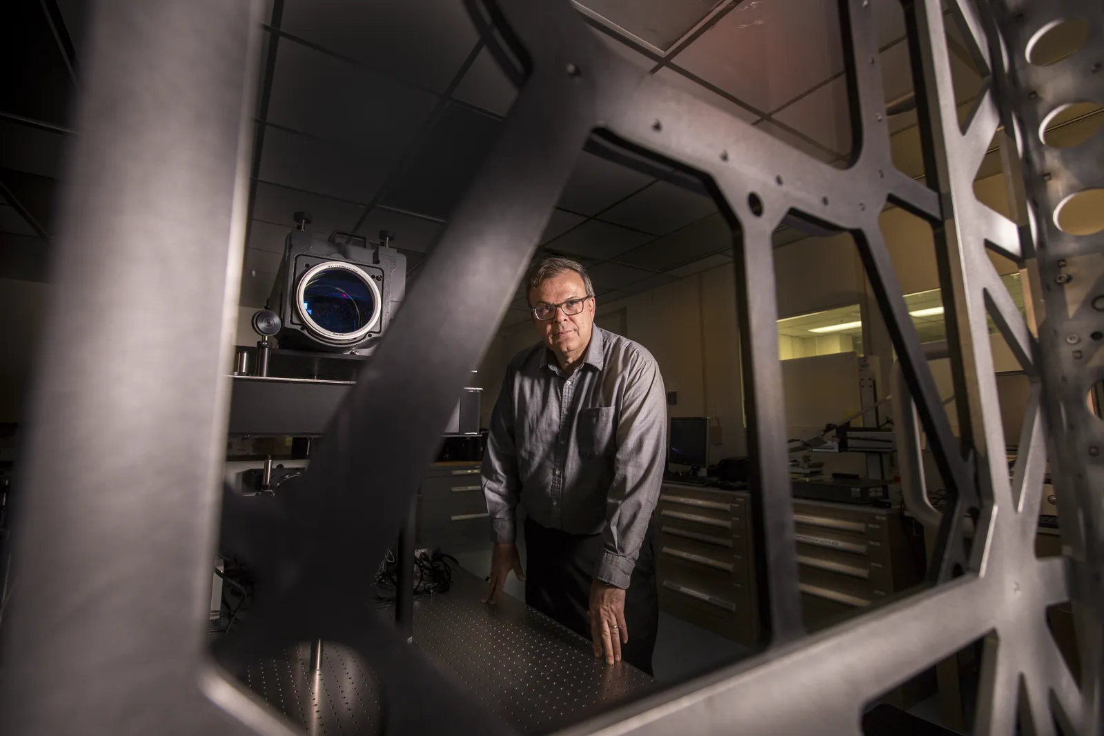 An engineer at an optical test frame